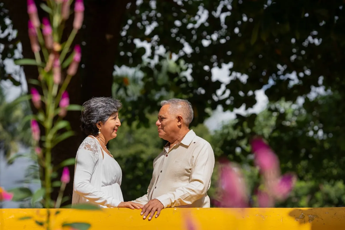 A happy elderly couple smiling warmly at each other outdoors