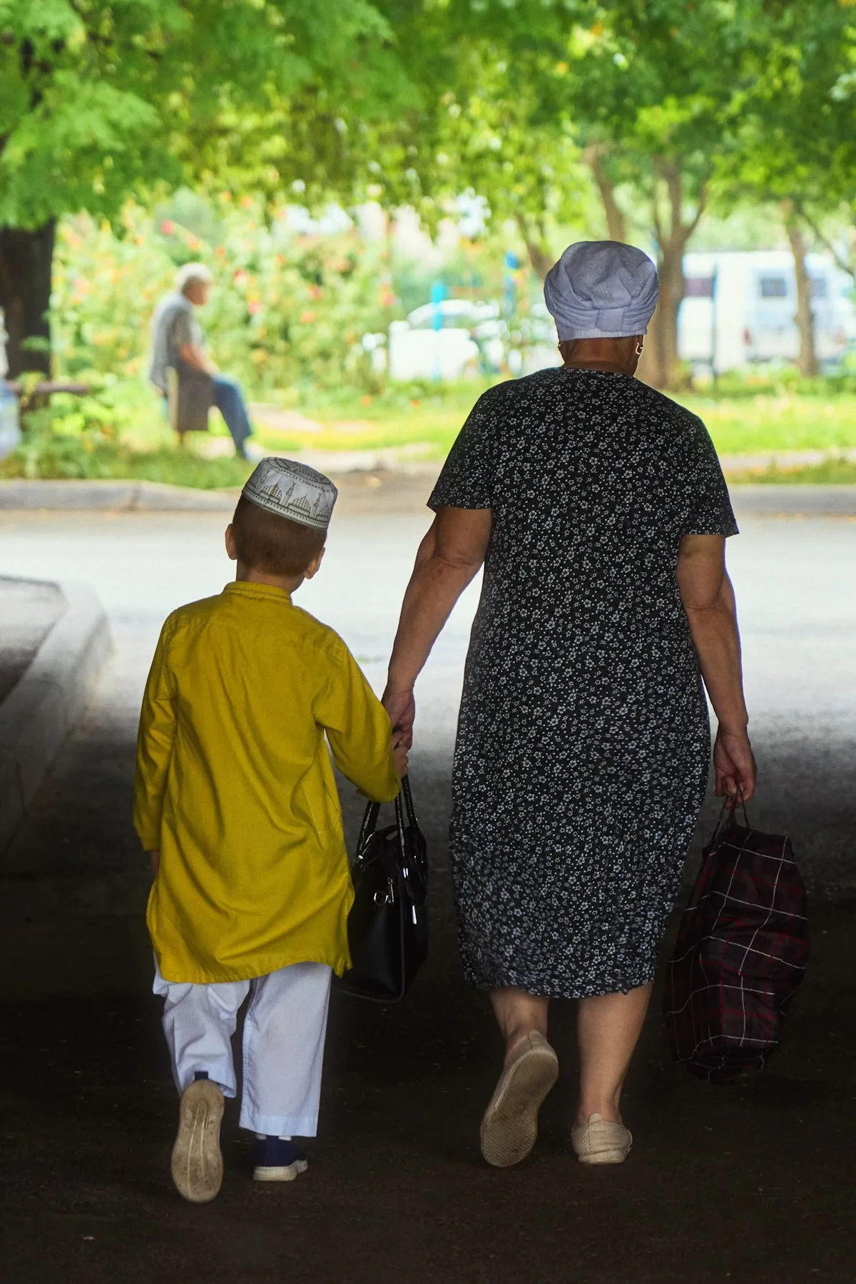 A grandmother and her young grandson holding hands tenderly