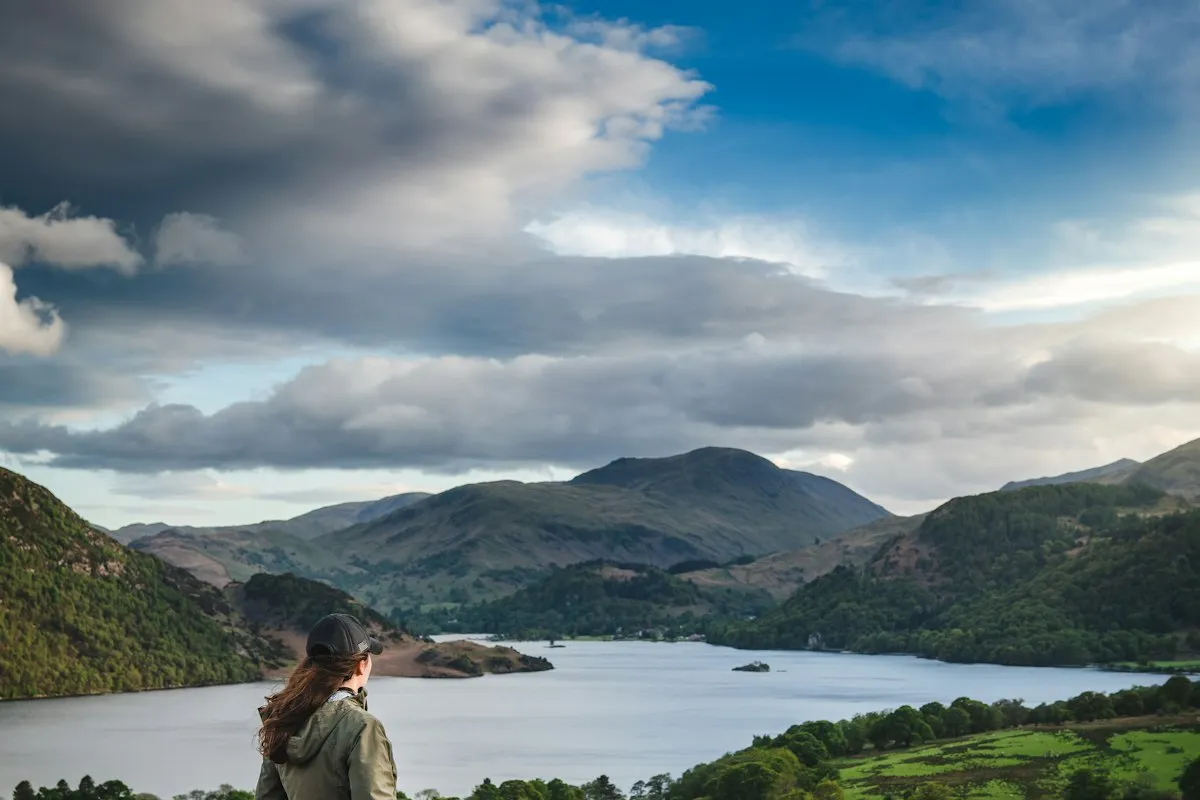 A woman looking out over Ullswater and the fells of the Lake District