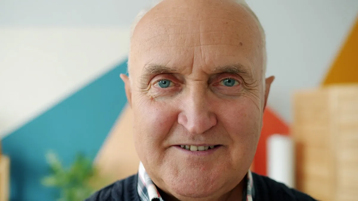 An elderly man with bright blue eyes smiling gently at the camera