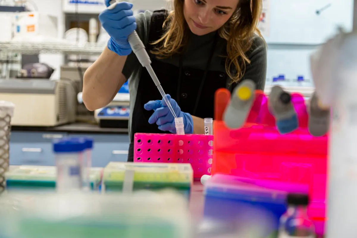 A scientist using a pipette at a research bench