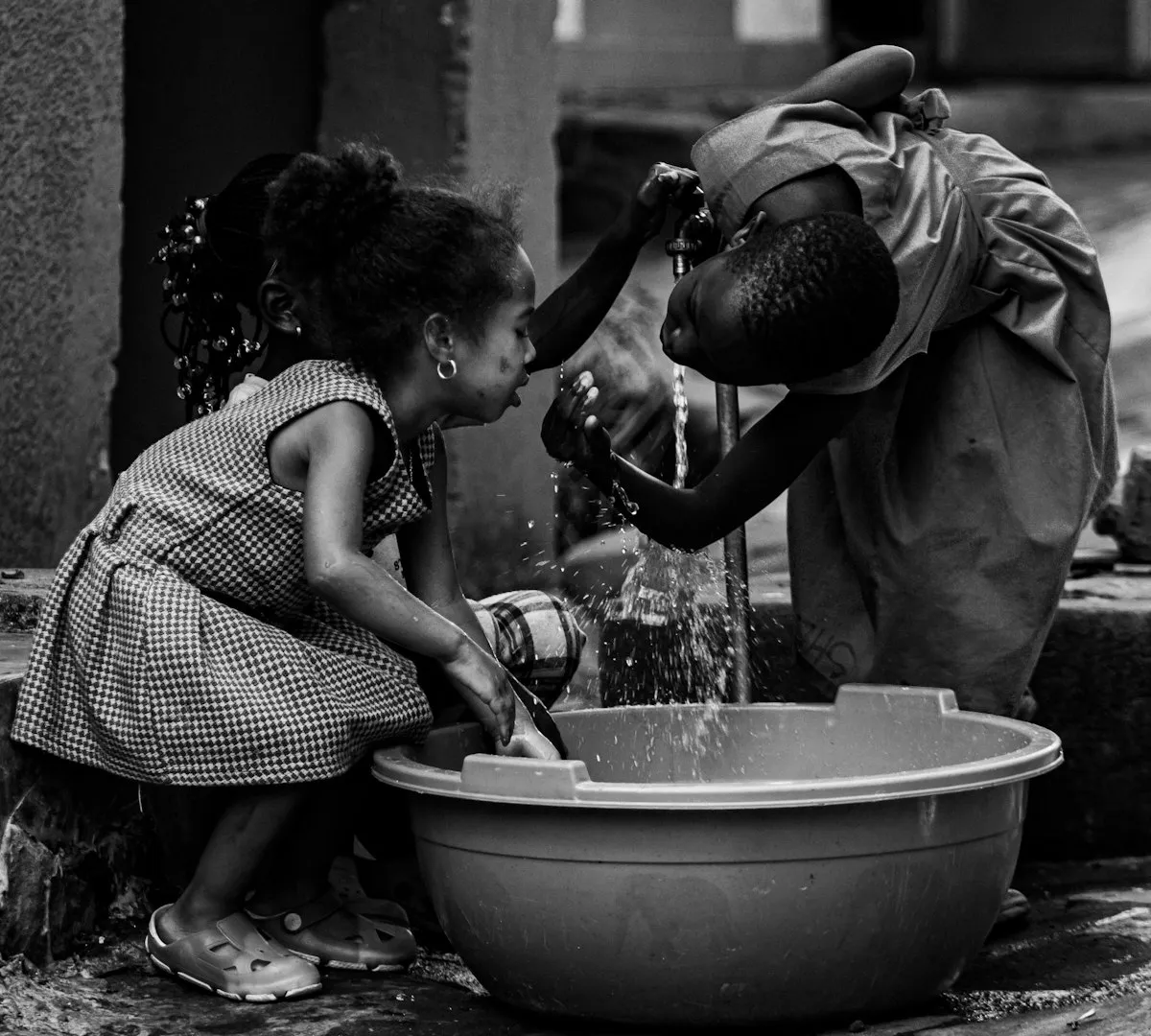 Children washing their hands at an outdoor water tap