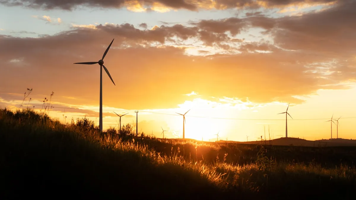 Wind turbines silhouetted across a green field at sunset